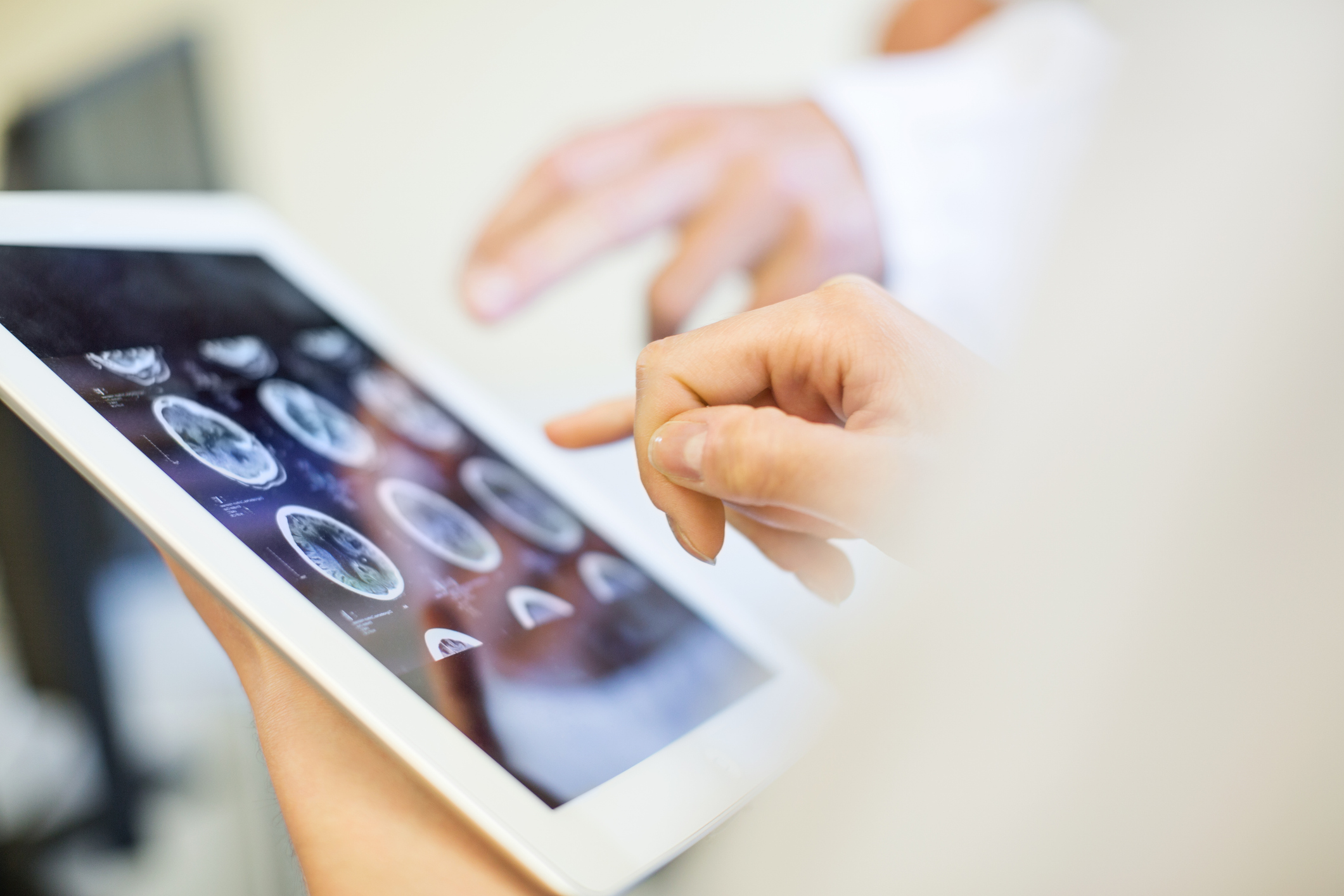 Medical team analyzing MRI scans on digital tablet